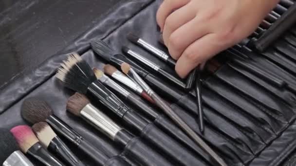 Due colpi. Truccatore professionista che applica eyeliner intorno all'intero occhio del modello — Video Stock