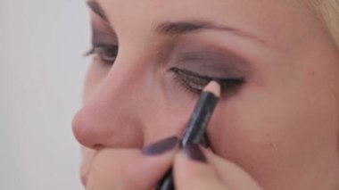 Atış kapatın. Uygulama modeli tüm göz çevresinde göz kalemi makyaj sanatçısı