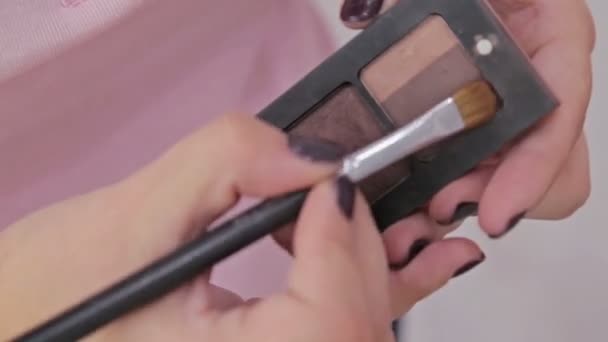 Un colpo ravvicinato. Make-up artist prendendo ombretti dalla tavolozza ombretti trucco — Video Stock
