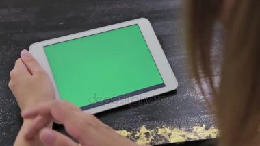 Yeşil ekranlı tablet bilgisayar kullanan kadın