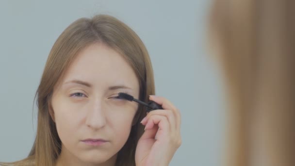 Mooie jonge vrouw zetten mascara — Stockvideo