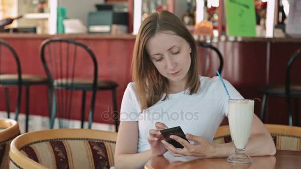 Woman using smartphone in cafe — Stock Video