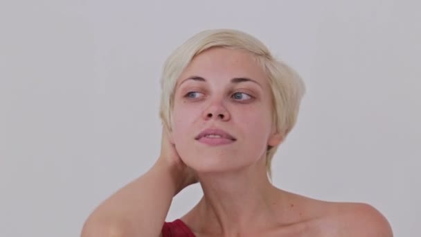 Jolie, jeune et blonde femme en robe rouge sans maquillage fixant les cheveux — Video