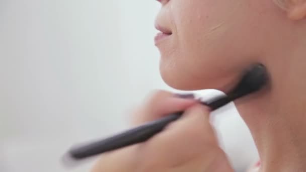 Maquillaje artista aplicando base tonal líquida en la cara de la mujer — Vídeo de stock