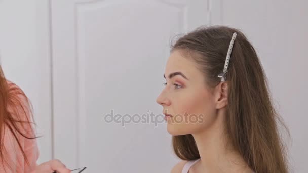 Dos disparos. Maquillador profesional aplicando sombra de ojos — Vídeos de Stock