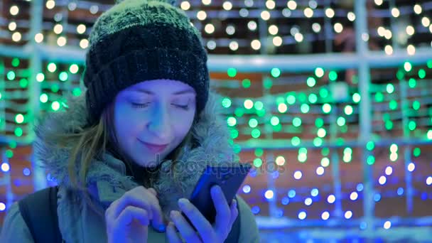 Young pretty woman using smartphone in the city at night — Stock Video