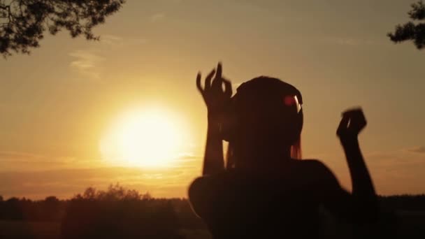 Kobieta zakładając słuchawki, słuchanie muzyki i tańca w lesie — Wideo stockowe