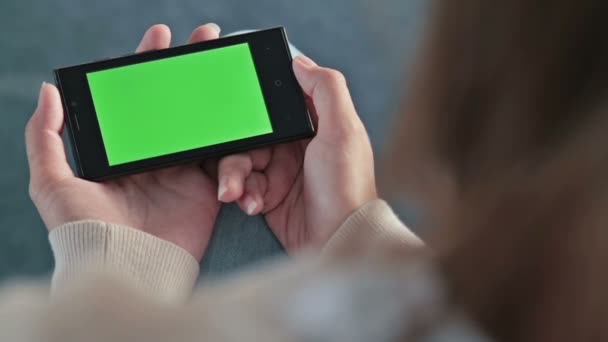 Mujer mirando el teléfono inteligente con pantalla verde — Vídeos de Stock