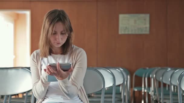Жінка використовує свій новий цифровий планшет ПК у порожній конференц-залі — стокове відео