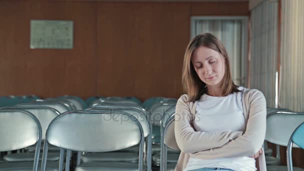 Женщина засыпает в пустом конференц-зале — стоковое видео