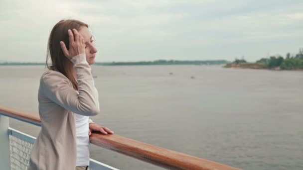 Giovane bella donna in piedi sul ponte della nave da crociera e guardando il fiume . — Video Stock