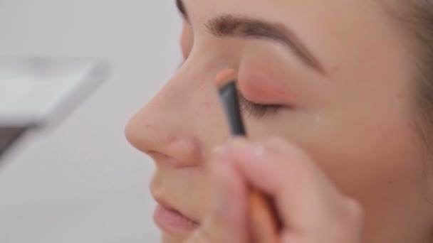 Primer plano. Maquillador profesional aplicando sombra de ojos — Vídeos de Stock