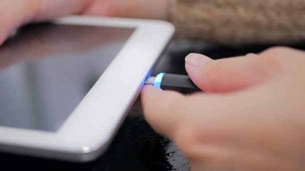 Femme main branchement noir câble de charge foudre dans la tablette numérique PC — Video