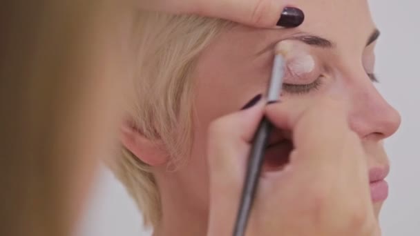 Professionele make-up artiest crème basis oogschaduw primer toepassen op model oog — Stockvideo