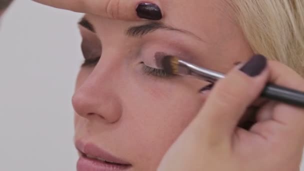 Profesionální maskérka aplikující oční stíny — Stock video