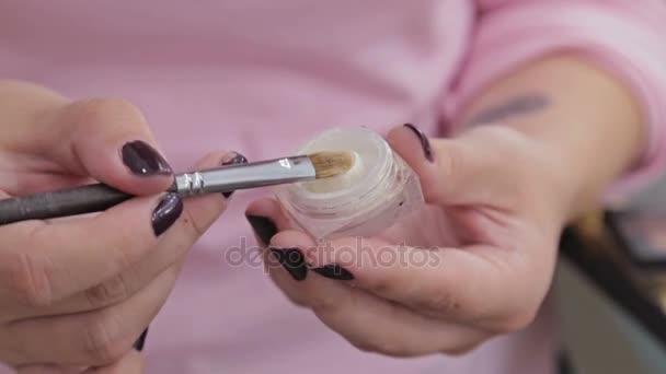 Três tiros. Artista de maquiagem profissional aplicando maquiagem no rosto do belo modelo sensual jovem — Vídeo de Stock
