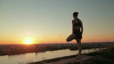 Gün batımında pratik Yoga parkta kadın