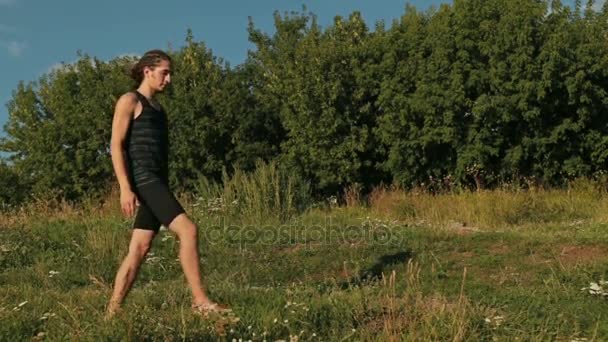 Uomo che pratica yoga nel parco al tramonto - signore della posa danza — Video Stock