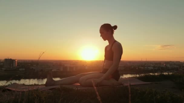 Frau praktiziert Yoga im Park bei Sonnenuntergang — Stockvideo