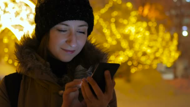 Młoda ładna kobieta przy użyciu smartfona w mieście w nocy — Wideo stockowe