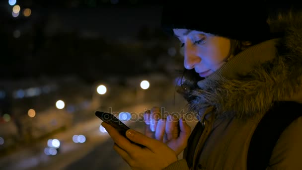 Jeune jolie femme utilisant un smartphone dans la ville la nuit — Video
