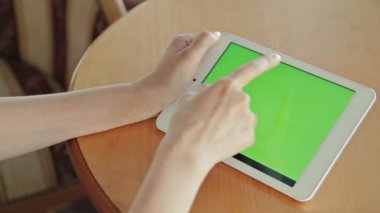 Kafede yeşil ekranlı tablet bilgisayar arayan kadın