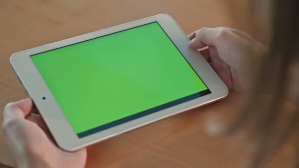 Femme regardant ordinateur tablette avec écran vert dans le café 