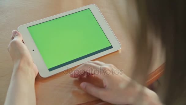 Vrouw die tablet pc kijkt met groen scherm in café — Stockvideo