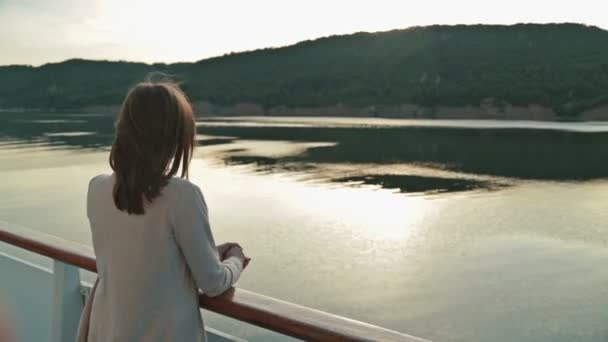 Młoda piękna kobieta stojąc na pokładzie statku wycieczkowego i patrząc na rzece. — Wideo stockowe