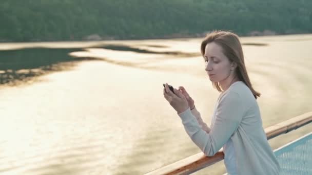 Kvinna med mobiltelefon på däck på kryssningsfartyg — Stockvideo