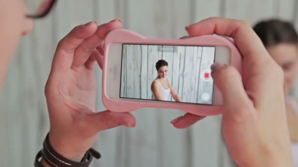 Maquilleuse prenant en photo sa cliente avec maquillage et coiffure élégante — Video