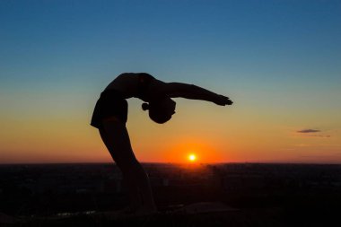 Gün batımında - pratik Yoga geri bırakma, tekerlek poz kadın