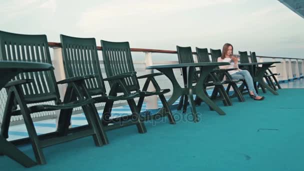 Femme avec tablette numérique PC assis sur le pont du bateau de croisière au lever du soleil — Video