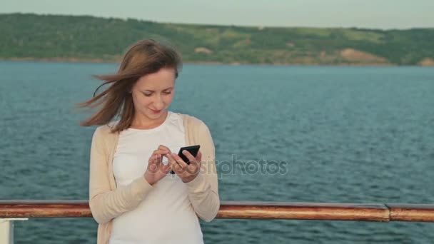 Kvinde ved hjælp af mobiltelefon på dækket af krydstogtskib – Stock-video