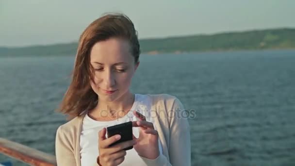Mujer usando teléfono móvil en la cubierta del crucero — Vídeos de Stock