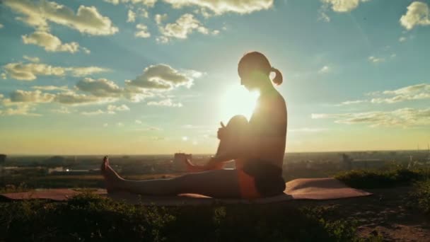 Frau praktiziert Yoga im Park bei Sonnenuntergang — Stockvideo