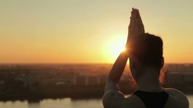 Gün batımında parkta yoga yapan sportif kadın - lotus mudra