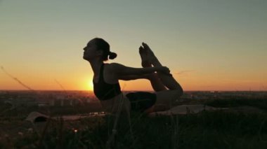 Gün batımında pratik Yoga parkta kadın