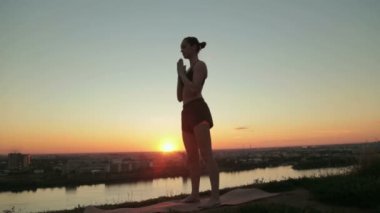 Gün batımında pratik Yoga parkta kadın