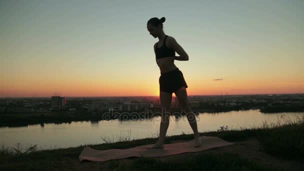 女人练习瑜伽在公园里看日落 — 图库视频影像