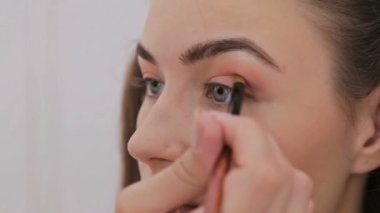 Profesyonel makyöz göz farı kullanıyor.