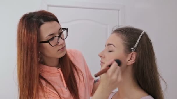 Toz kadın yüzüne uygulama profesyonel makyaj sanatçısı — Stok video