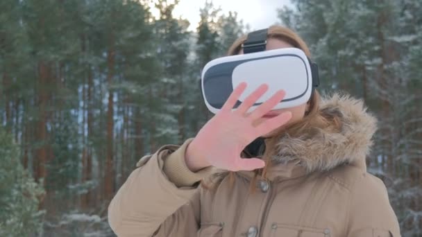 Mujer utiliza gafas de realidad virtual en bosque de invierno — Vídeo de stock