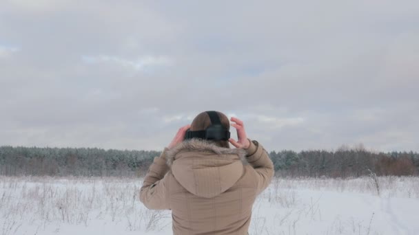 Femme portant et utilisant des lunettes de réalité virtuelle dans la forêt d'hiver — Video