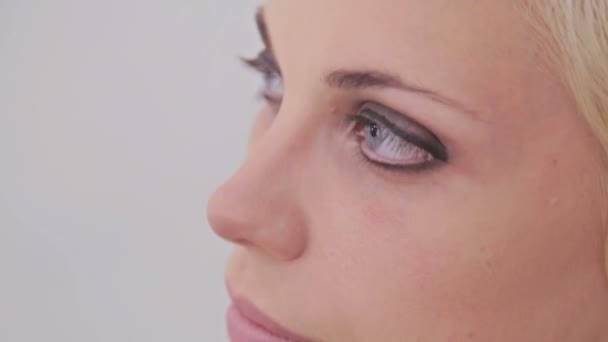 Primer plano. Maquillaje artista aplicando delineador de ojos alrededor de todo el ojo del modelo — Vídeos de Stock