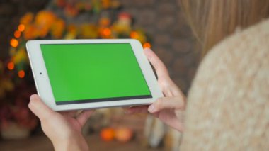 Yeşil ekranlı tablet bilgisayara bakan kadın