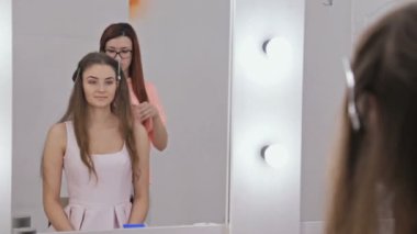 Profesyonel kuaför saç modeli için genç kadın uzun saçlı güzel yapıyor