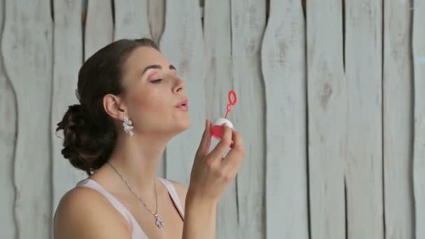 Красивая женщина с красивым макияжем и элегантной прической надувая пузыри — стоковое видео