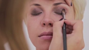 Profesyonel makyöz göz farı kullanıyor.