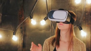 Sanal gerçeklik gözlüğü kullanan genç bir kadın.